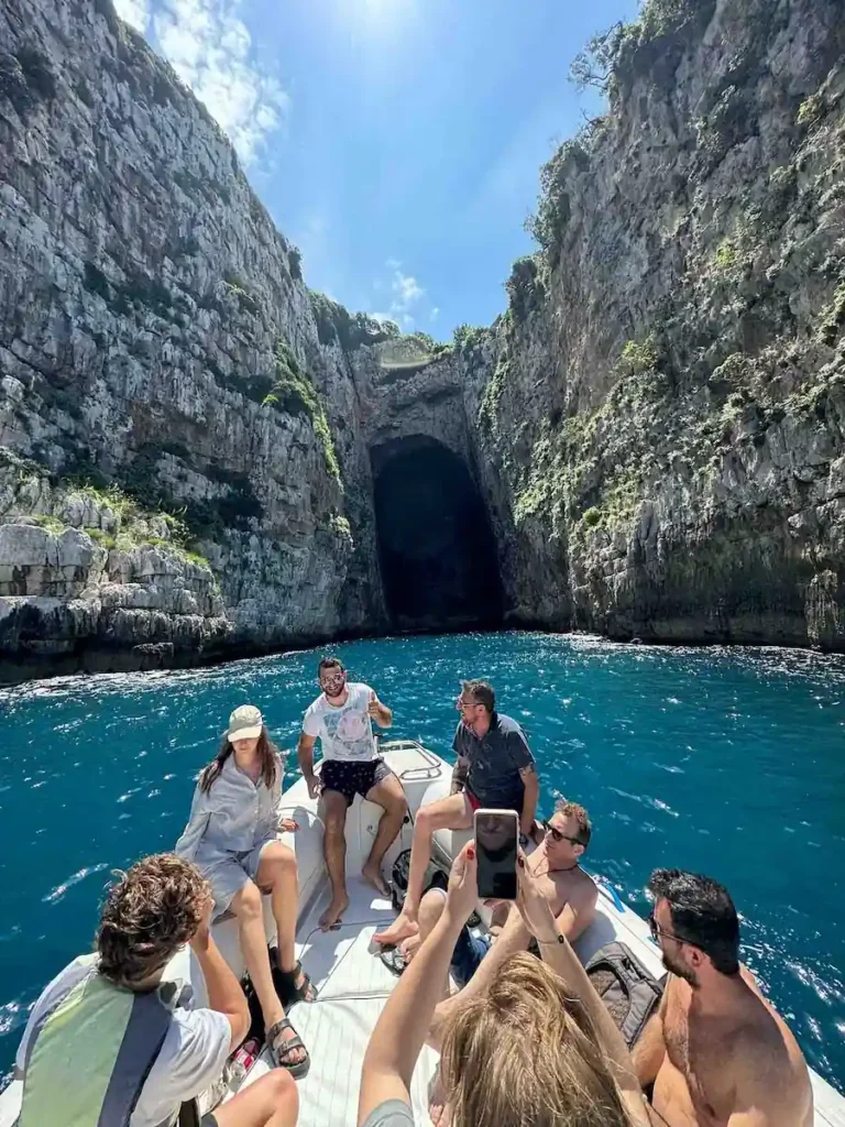 Tourists enjoying a speed boat tour at the entrance of Haxhi Ali Cave in Vlore, Albania.