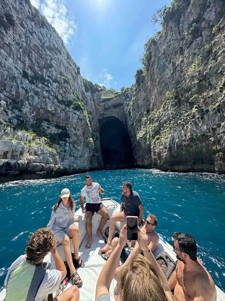 Tourists enjoying a speed boat tour at the entrance of Haxhi Ali Cave in Vlore, Albania.